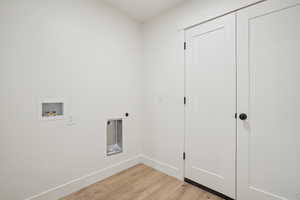 Laundry room with light wood-style flooring, hookup for a washing machine, and hookup for an electric dryer