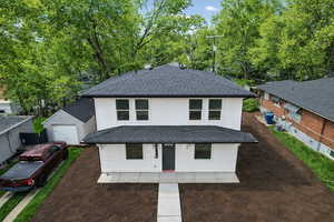 View of front facade with a shingled roof and covered porch