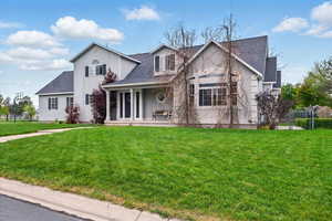 View of front of home featuring covered porch, a shingled roof, and stucco siding