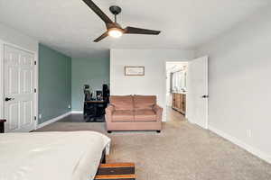 Bedroom featuring a desk, ceiling fan, and carpet