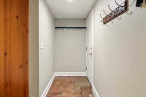 Entryway featuring stone finish floors and baseboards