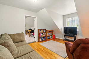 Living area with light wood finished floors and a textured ceiling