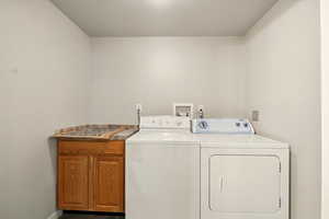 Laundry area with washer and clothes dryer and cabinet space