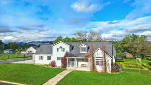 Cape cod home featuring covered porch and a mountain view
