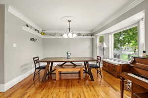 Dining space with ornamental molding and light wood finished floors