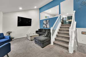 Living room with recessed lighting, stairs, carpet, and lofted ceiling