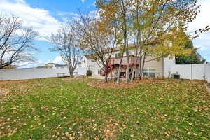 Back of property with a fenced backyard, a deck, a gate, and stairway