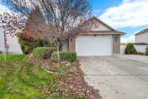 Obstructed view of property featuring brick siding, driveway, and a garage