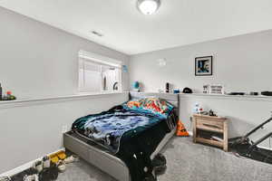 Carpeted bedroom featuring a textured ceiling
