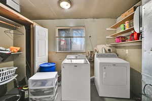 Washroom featuring separate washer and dryer and concrete floors