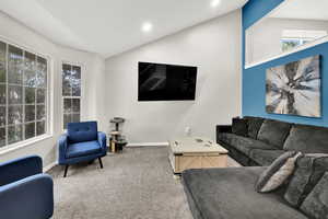 Carpeted living room featuring lofted ceiling and recessed lighting