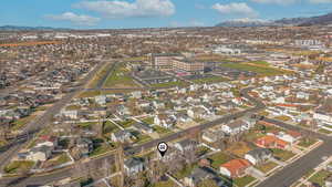 Aerial view of property and surrounding area featuring mountains and nearby urban area