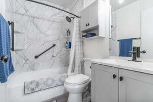 Bathroom with vanity and shower / bath combination with curtain