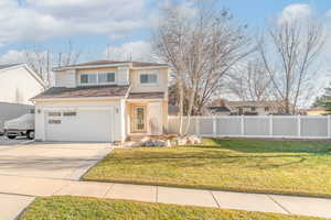Traditional-style home featuring concrete driveway and an attached garage