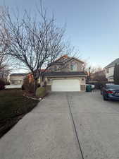 Traditional-style house featuring concrete driveway and a garage