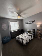 Bedroom with carpet flooring, a textured ceiling, and ceiling fan