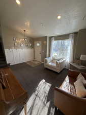 Carpeted living area featuring a textured ceiling, recessed lighting, stairs, and lofted ceiling