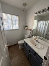 Bathroom featuring vanity, dark tile patterned flooring, and a shower with curtain