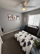 Bedroom featuring a textured ceiling, carpet, and a ceiling fan