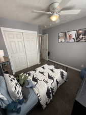 Bedroom featuring carpet flooring, a closet, ceiling fan, and a textured ceiling