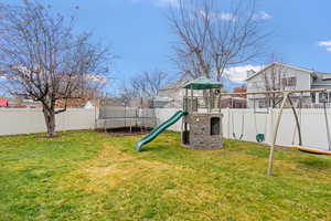 View of jungle gym with a trampoline, a fenced backyard, and a residential view