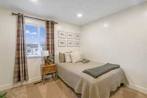 Bedroom with light colored carpet and recessed lighting