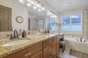 Bathroom with a garden tub, double vanity, light tile patterned floors, and a shower stall
