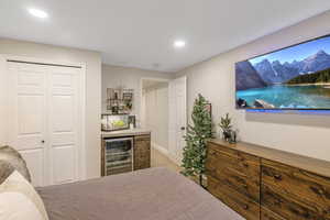 Bedroom featuring wine cooler, a closet, light carpet, and recessed lighting
