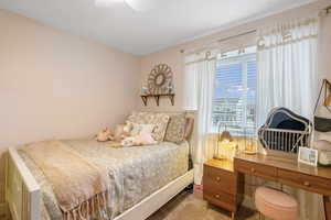 Carpeted bedroom featuring a ceiling fan