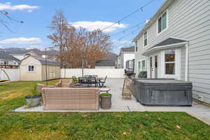 Fenced backyard featuring a patio area, a storage shed, a hot tub, and french doors