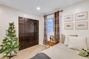 Bedroom with a closet and light colored carpet