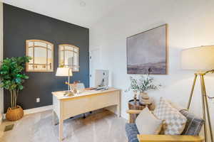 Carpeted office space featuring baseboards