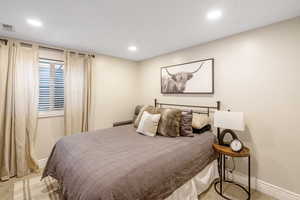 Bedroom with light colored carpet and recessed lighting