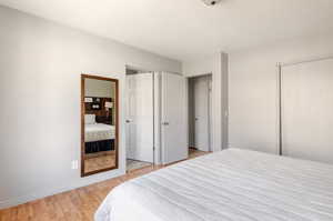 Bedroom with light wood finished floors and a closet