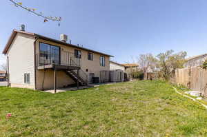 Rear view of property featuring stairway, a fenced backyard, a deck, and a patio