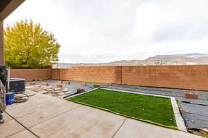 Fenced backyard featuring a patio and a mountain view