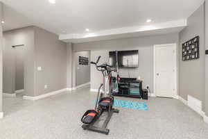 Exercise room with baseboards and recessed lighting