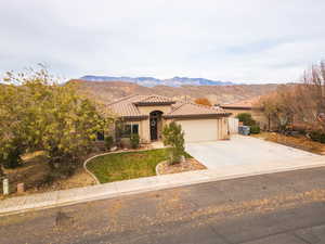Mediterranean / spanish home with driveway, a mountain view, stucco siding, and a garage