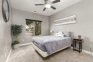 Carpeted bedroom featuring a ceiling fan and baseboards