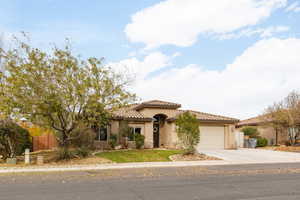 Mediterranean / spanish-style house featuring stucco siding, a tiled roof, concrete driveway, and a garage