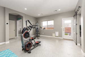 Exercise area with a barn door, arched walkways, and recessed lighting