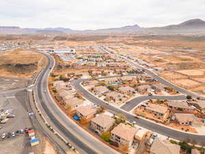 Aerial view of property and surrounding area featuring mountains and nearby suburban area