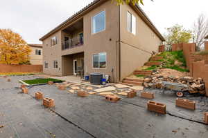 Rear view of property with a patio, a fenced backyard, a balcony, stucco siding, and a tiled roof