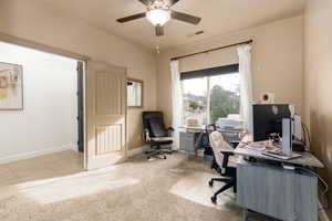 Office area featuring light carpet and a ceiling fan