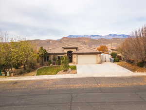 Mediterranean / spanish home with a mountain view, a gate, concrete driveway, a garage, and a tiled roof