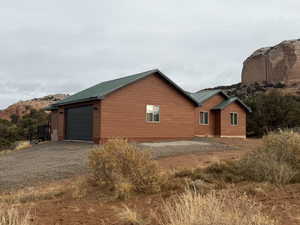 View of property exterior with a metal roof, a garage, driveway, and a mountain view