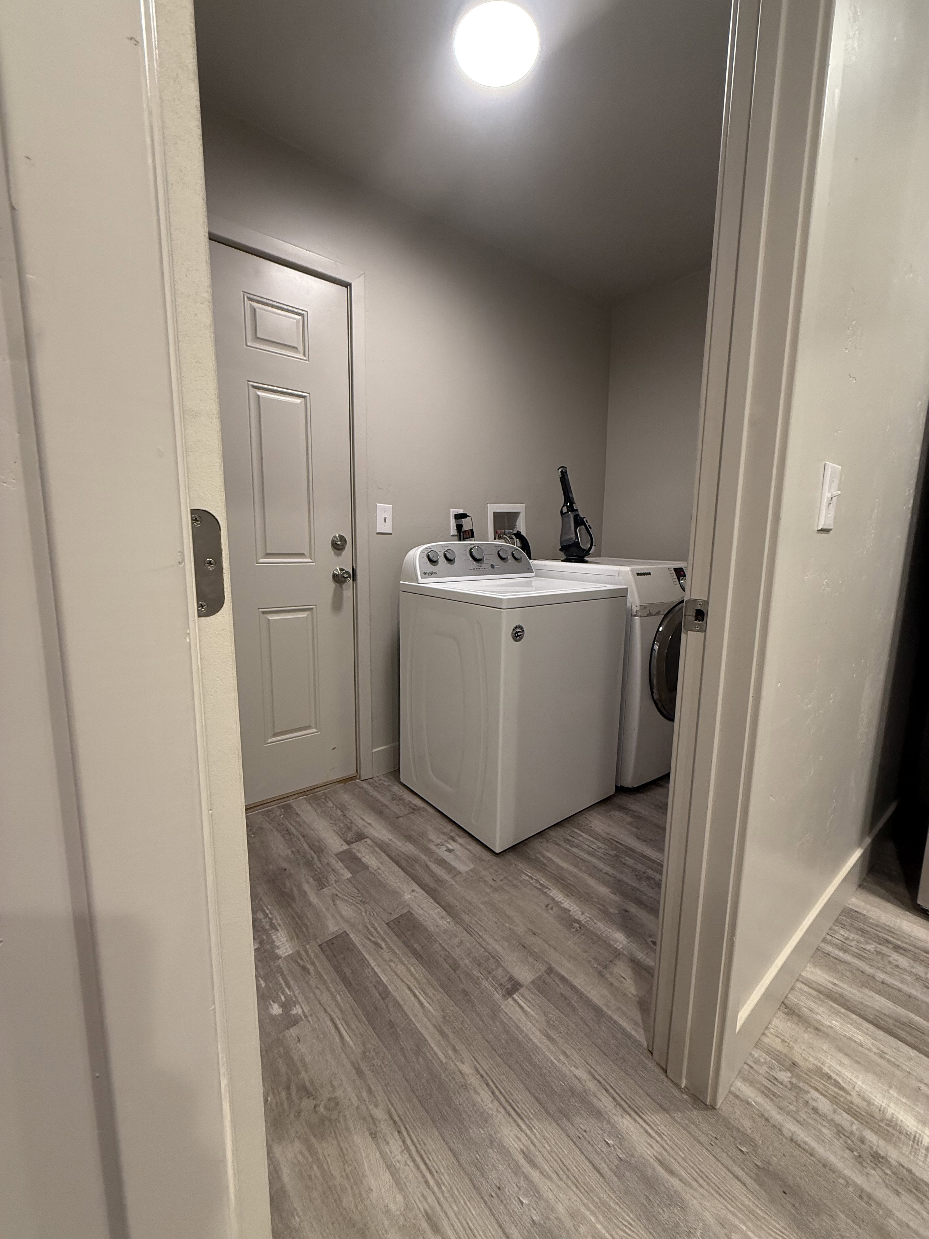 Laundry room with light wood-style flooring and washing machine and dryer