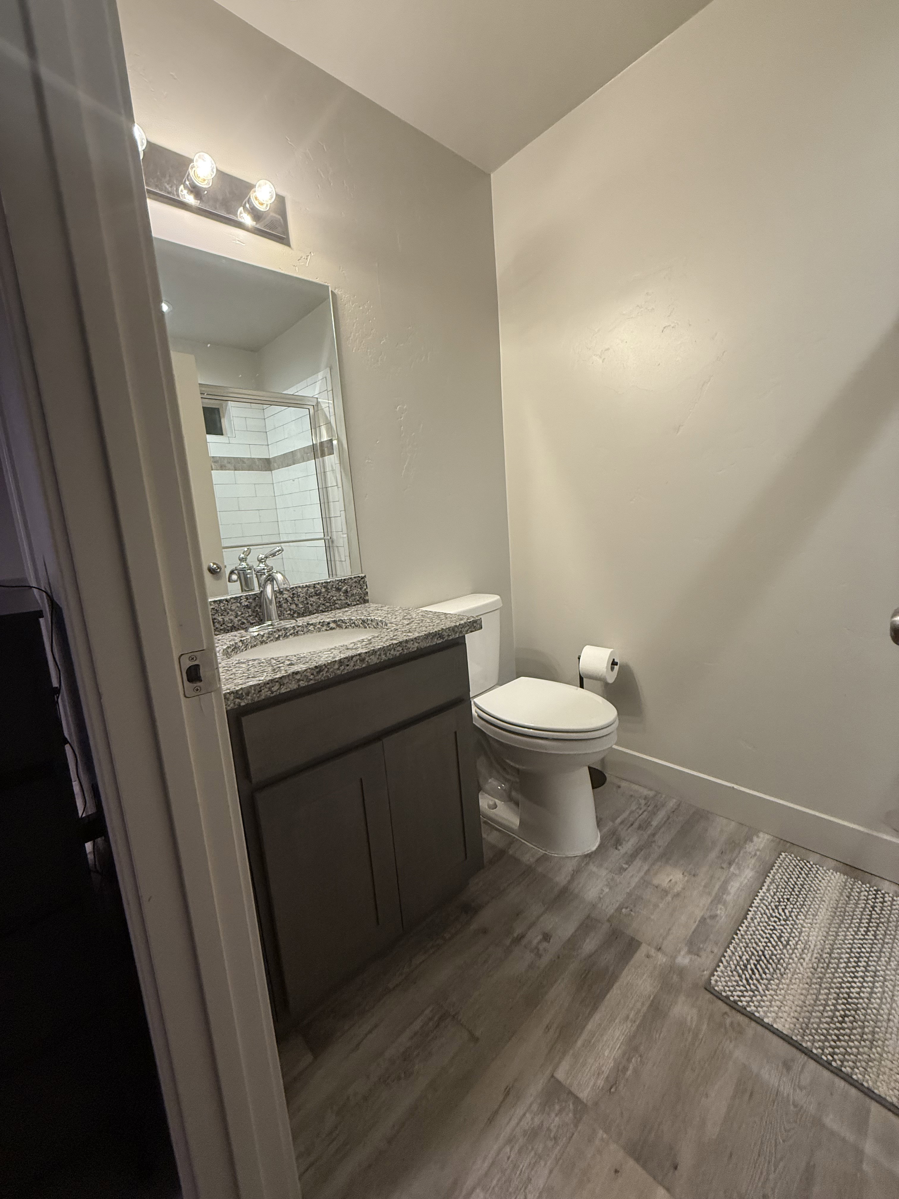 Bathroom with vanity, dark wood-type flooring, and tiled shower