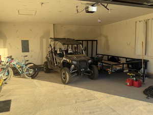 Garage featuring electric panel and a garage door opener