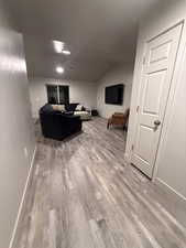 Living area with light wood-type flooring and lofted ceiling